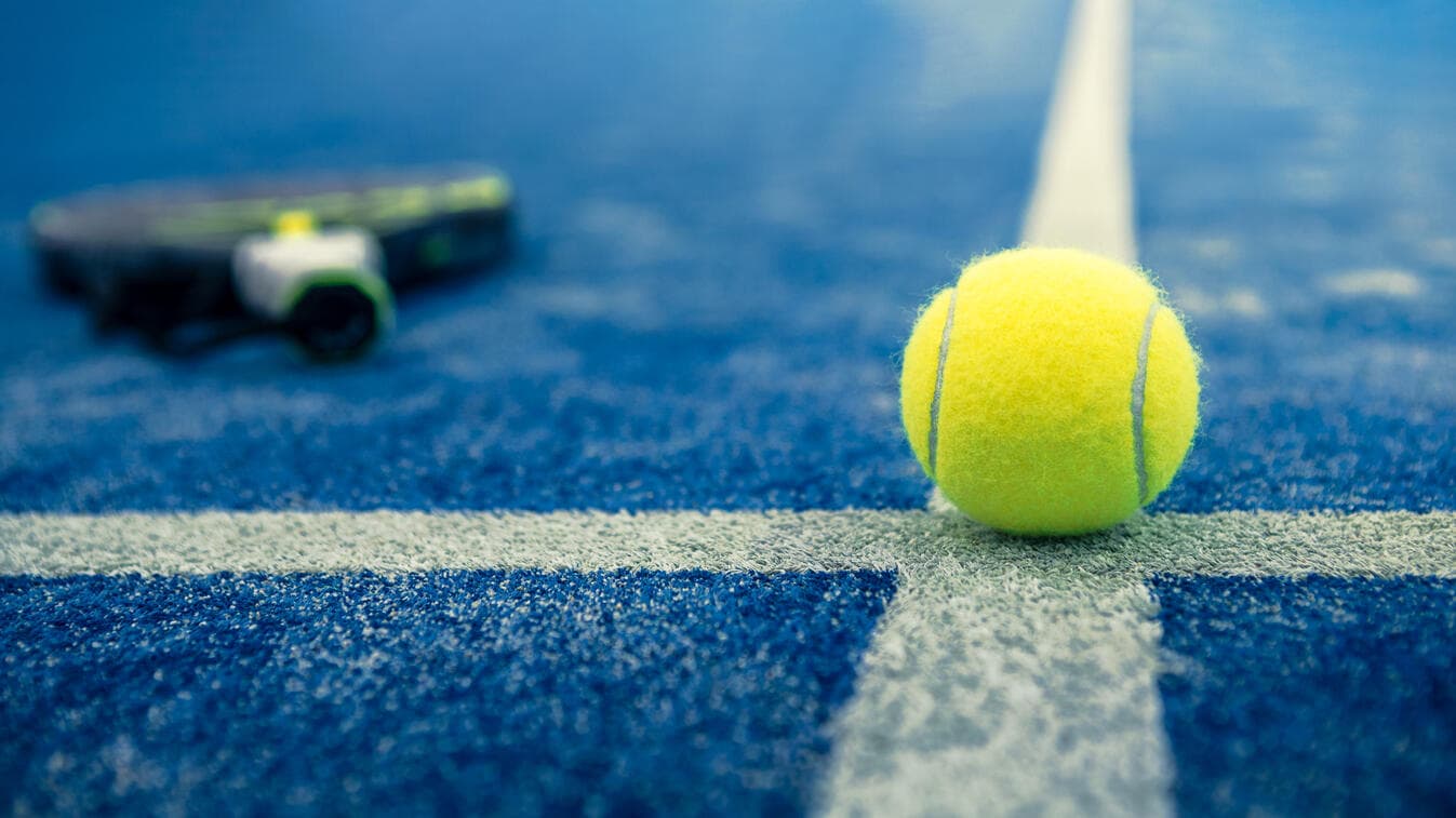 Détail terrain padel — balle et raquette